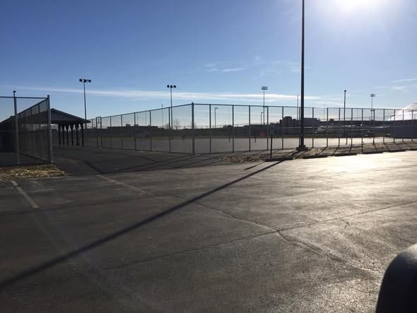 Tall chain-link fencing around a municipal athletic field