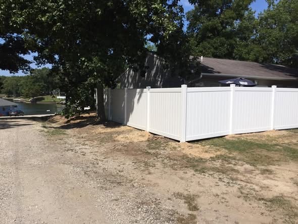White vinyl privacy fence at a lakeside property
